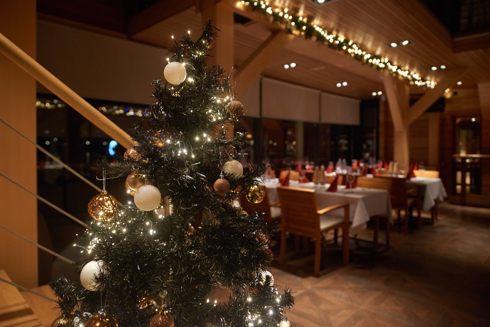 A decorated Christmas tree beside the laid tables