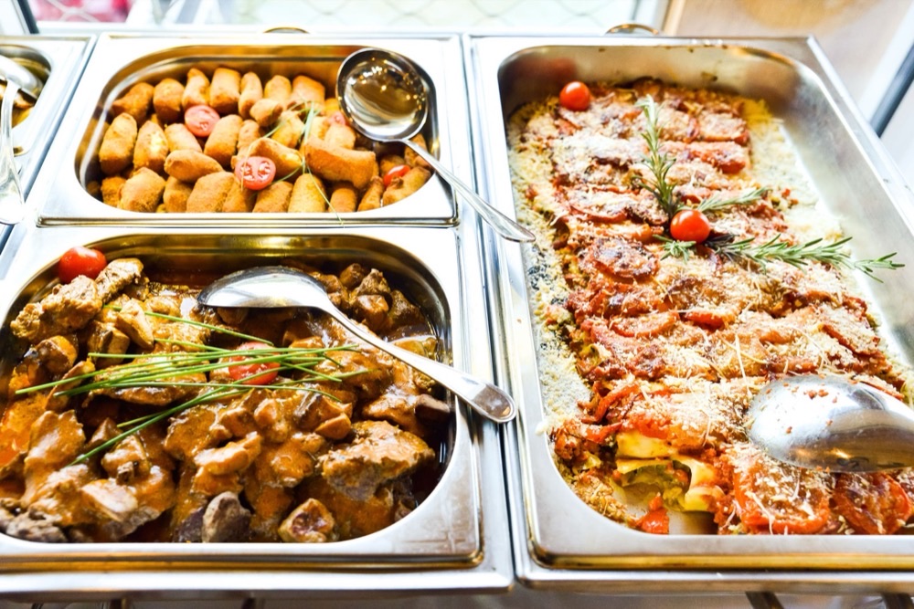 Stew, croquettes and baked vegetables in chafing dishes